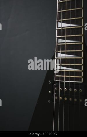 Rogner le cliché de mise au point douce de guitare électrique en forme de V noir sur fond de grunge foncé Banque D'Images