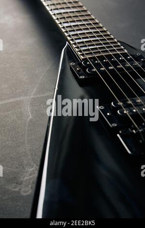 Rogner le cliché de mise au point douce de guitare électrique en forme de V noir sur fond de grunge foncé Banque D'Images