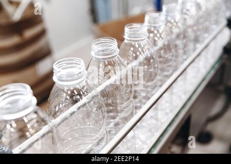 Bouteilles en plastique PET sur une ligne automatisée de nourriture, l'industrie de l'embouteillage de lait et de yaourt dans l'usine laitière. Banque D'Images