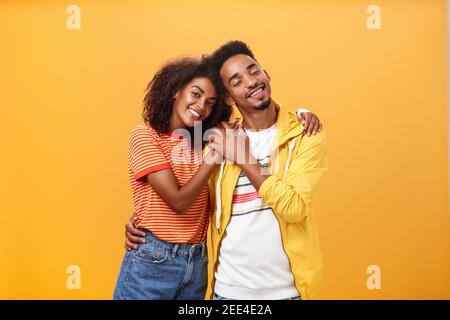 Ils s'aiment les uns les autres. Portrait de deux hommes et femmes afro-américains charmants en relation avec le sourire réconfortant en touchant les mains souriantes Banque D'Images