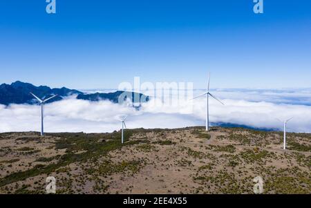 Générateurs de vent avec fond de nuages et ciel bleu le jour d'été clair sur la chaîne de montagnes vue aérienne, Madère, Portugal. Concept d'énergie verte Banque D'Images
