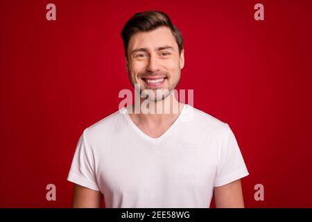 Photo d'une jeune personne souriant souriant sympathique et satisfaite isolé sur fond bordeaux Banque D'Images