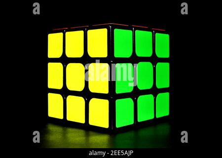 Rubik's Cube isolé sur fond noir. Couleurs jaune et vert Banque D'Images