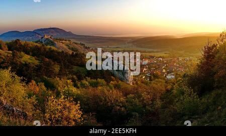 Photo panoramique d'un magnifique paysage d'automne, château ruine au-dessus du petit village dans Pálava paysage protégé en république tchèque au lever du soleil Banque D'Images