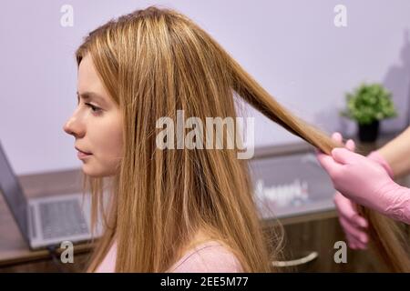 Trichocopie-ordinateur de diagnostic à la cliente femelle par cosmetologiste professionnel, vue latérale sur la vérification de l'état et de la structure des cheveux en utilisant m spécial Banque D'Images