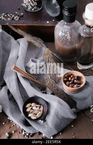 Photo verticale d'un fond rustique avec différentes épices et bouteilles Banque D'Images