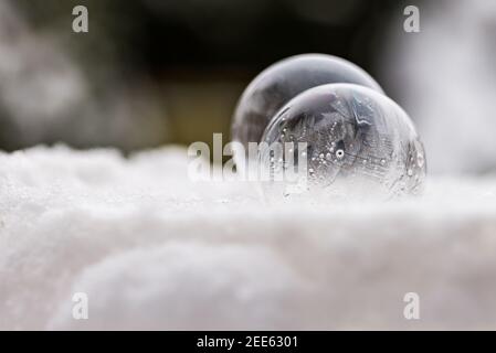 Deux bulles de savon congelées gèlent à basse température sous zéro sur la neige Banque D'Images