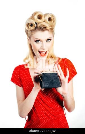 Concept d'économies. Rétro pinup femme économie d'argent dans la caisse. Épinglez une fille dans un style vintage femme au foyer. Banque D'Images