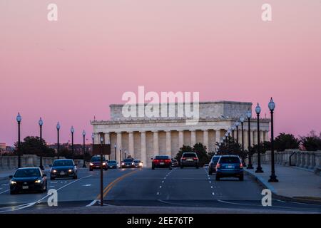 Le ciel devient rose pâle après le coucher du soleil, tandis que les voitures traversent le pont Arlington Memorial Bridge. Le Lincoln Memorial peut être vu dans l'arrière-gro Banque D'Images