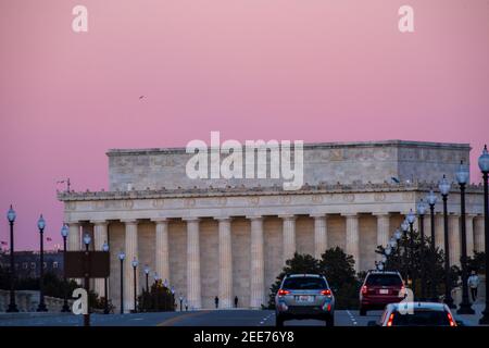 Le ciel devient rose pâle après le coucher du soleil, tandis que les voitures traversent le pont Arlington Memorial Bridge. Le Lincoln Memorial peut être vu dans l'arrière-gro Banque D'Images