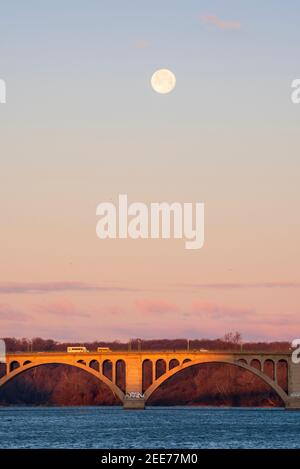 La pleine lune se lève tôt le matin au-dessus de Key Bridge à Washington, DC. Banque D'Images