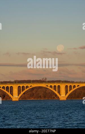 La pleine lune se lève tôt le matin au-dessus de Key Bridge à Washington, DC. Banque D'Images