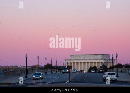 Le ciel devient rose pâle après le coucher du soleil, tandis que les voitures traversent le pont Arlington Memorial Bridge. Le Lincoln Memorial peut être vu dans l'arrière-gro Banque D'Images