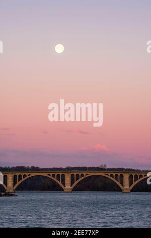 La pleine lune se lève tôt le matin au-dessus de Key Bridge à Washington, DC. Banque D'Images