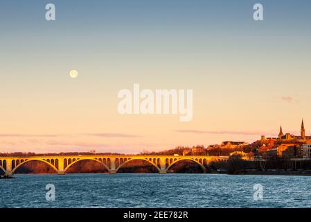 La pleine lune se lève tôt le matin au-dessus de Key Bridge à Washington, DC. Banque D'Images