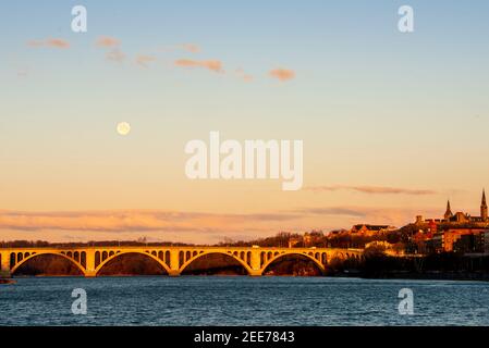 La pleine lune se lève tôt le matin au-dessus de Key Bridge à Washington, DC. Banque D'Images