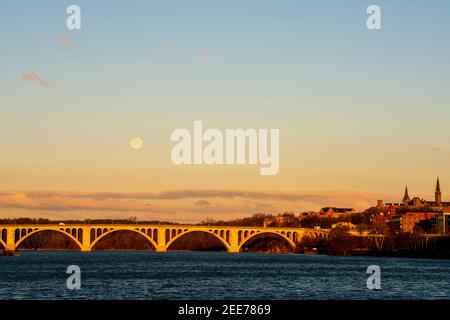 La pleine lune se lève tôt le matin au-dessus de Key Bridge à Washington, DC. Banque D'Images