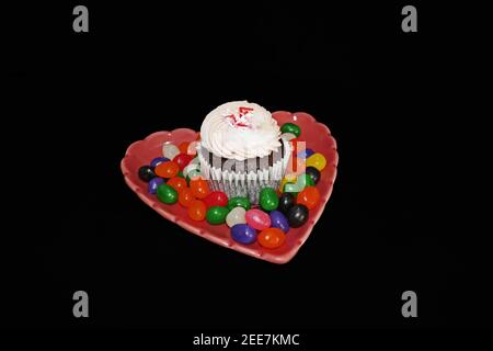 Cupcake aux fraises sur une assiette en forme de coeur avec friandises Banque D'Images