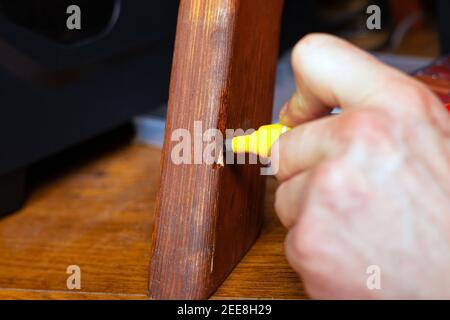 restauration et réparation de meubles en bois la main principale ferme la rayure avec un marqueur spécial gros plan Banque D'Images