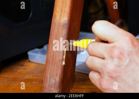restauration et réparation de meubles en bois la main principale ferme la rayure avec un marqueur spécial Banque D'Images