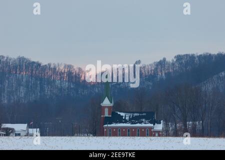 L'église luthérienne de Wegan (Missouri Synod) dans le comté de Jackson, DANS un coucher de soleil sur une neige après-midi couvert. Banque D'Images