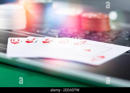 Plate-forme de jeu en ligne, casino et affaires de jeu. Cartes, dés et pièces de jeu multicolores sur le clavier de l'ordinateur portable. Banque D'Images