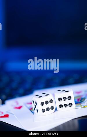 Plate-forme de jeu en ligne, casino et affaires de jeu. Cartes, dés et pièces de jeu multicolores sur le clavier de l'ordinateur portable. Banque D'Images