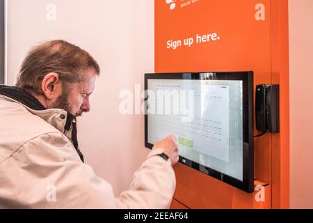 Man utilise Ikea Family Digital s'inscrire dans le magasin. Banque D'Images