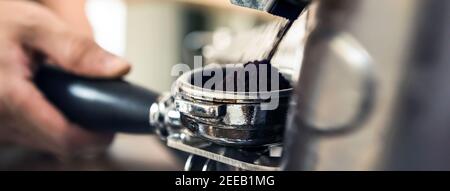 Machine à moulin automatique pour moudre les grains de café dans le panier porte-filtre Banque D'Images