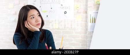 Jeune asiatique femme étudiant à l'université en mer pensant à la main sur joue dans la salle de classe, bannière panoramique avec espace de copie Banque D'Images