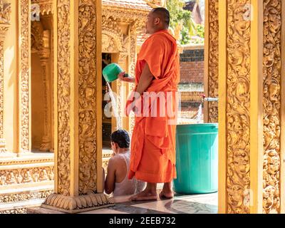 Monk exécutant une bénédiction d'eau sur un homme à Wat Kean Kliang, un temple bouddhiste à Phnom Penh, au Cambodge, situé entre le Tonle SAP et la rive du Mékong Banque D'Images