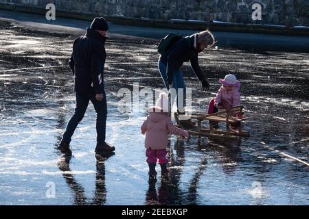 Famille sur la glace dans le port de Lemmer. La femme aide sa fille à se lever après qu'elle glisse Banque D'Images