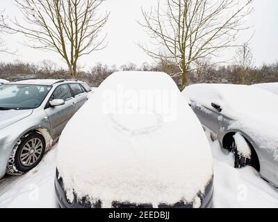 Voiture enterrée par la neige avec coeur peint. Nuageux matin d'hiver Banque D'Images