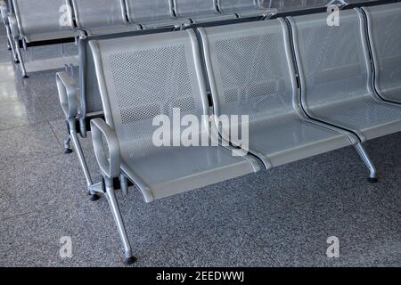 Rangée de chaises en métal pour les clients d'aéroport. Espace public moderne. Concept d'attente dans l'aéroport. Mobilier métallique perforé. Être inconfortable Banque D'Images