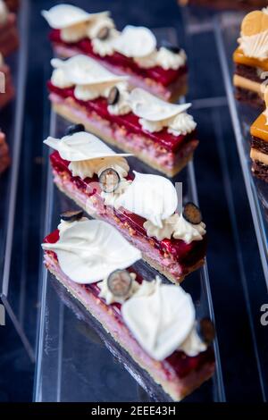 Gros plan sur la mousse rouge aux myrtilles, le brownie, les ailes de chocolat blanc et la crème au beurre. Banque D'Images