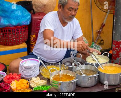 Hoi an, Vietnam - 28 juillet 2019 : restaurant local avec vendeur de nourriture et bol à soupe. Cuisine de rue vietnamienne. Le vieil homme fait cuire la soupe et le riz. Culture traditionnelle an Banque D'Images