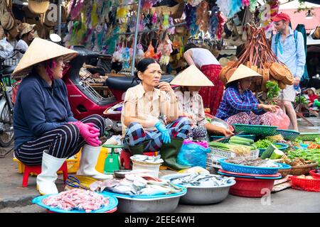 Hoi an, Vietnam - 28 juillet 2019: Vendeurs de marché du poisson en chapeau conique vietnamien. Vue sur le marché alimentaire local. Légumes et viande frais biologiques vendus à partir de la Lola Banque D'Images