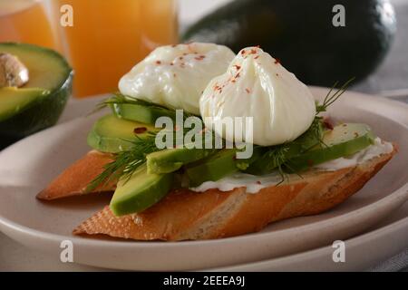 Œufs pochés et sandwichs avec avocat. Tranches d'avocat et d'œuf sur du pain grillé pour un petit déjeuner sain ou une collation Banque D'Images