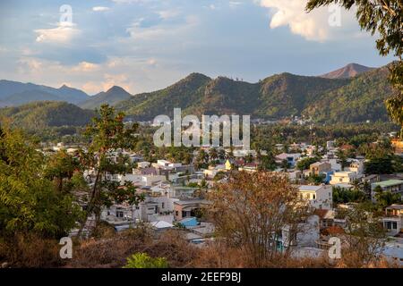 Nha Trang, Vietnam - 24 juillet 2019 : vue sur la ville avec des bâtiments et des montagnes lointaines à la lumière du coucher du soleil. Panorama de la ville asiatique paisible. Asie du Sud : téléphone Banque D'Images