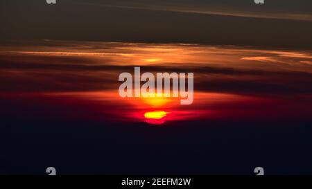 Coucher de soleil époustouflant au-dessus des silhouettes des montagnes des Vosges avec ciel nuageux et coloré, vue depuis le sommet de Schauinsland, Forêt Noire, Allemagne en hiver. Banque D'Images