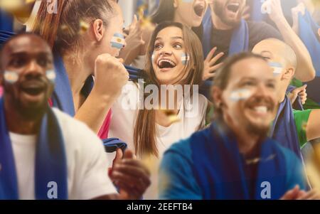 Le football argentin, les fans de football applaudissent leur équipe avec des foulards bleus au stade. Les fans enthousiastes applaudissent un but, soutenant les joueurs favoris. Concept de sport, émotions humaines, divertissement. Banque D'Images