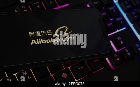 Viersen, Allemagne - février 9. 2021: Gros plan de l'écran de smartphone avec le logo du groupe alibaba sur un clavier d'ordinateur flou Banque D'Images