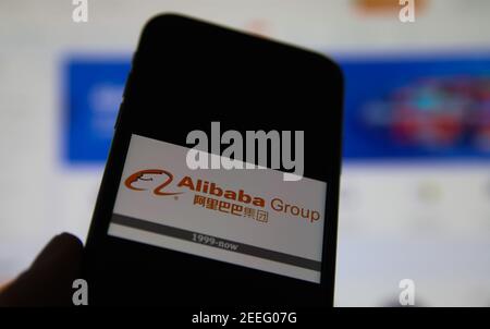 Viersen, Allemagne - février 9. 2021: Gros plan de l'écran de smartphone avec le logo du groupe alibaba sur un clavier d'ordinateur flou Banque D'Images