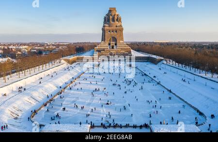 Leipzig, Allemagne. 13 février 2021. Les Leipzigers patinent sur la glace sur le lac des mille larmes devant le Monument de la bataille des Nations. Après des jours de gel, au moins les étangs peu profonds invitent au patinage. (Vue aérienne avec drone) Credit: Jan Woitas/dpa-Zentralbild/ZB/dpa/Alamy Live News Banque D'Images