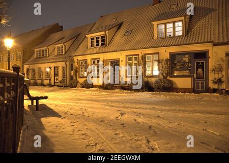 Schleswig, Allemagne, le 15 février 2021, le lieu de pêche Holm dans la vieille ville de Schleswig avec le cimetière central et la chapelle de cimetière du Holm populaire. Photo sur une belle soirée d'hiver avec de la neige fraîche. Le nom du règlement est basé sur le mot Holm en allemand du Nord ou en danois. C'est une petite île. | utilisation dans le monde entier Banque D'Images