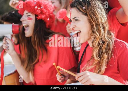Des supporters fous de football jouent à la batterie et crient tout en soutenant leur Équipe - concentrez-vous sur la bonne femme Banque D'Images
