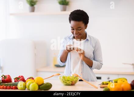 Femme Blogger prendre une photo de la cuisine saine de dîner dans la cuisine Banque D'Images