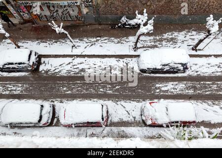 Voitures totalement couvertes de neige pendant la tempête de neige dans le quartier Ekssarchia, Athènes, la capitale de la Grèce, l'Europe. Banque D'Images