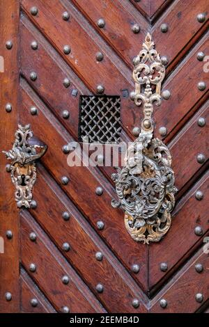 Vieilles portes en bois avec rivets, poignées anciennes et barres métalliques. Les portes sont marron avec des poignées de couleur or. Banque D'Images