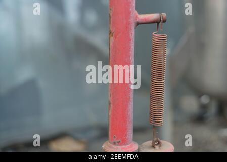 Gros plan d'un ressort rouille d'époque sur un bras d'une machine. Banque D'Images
